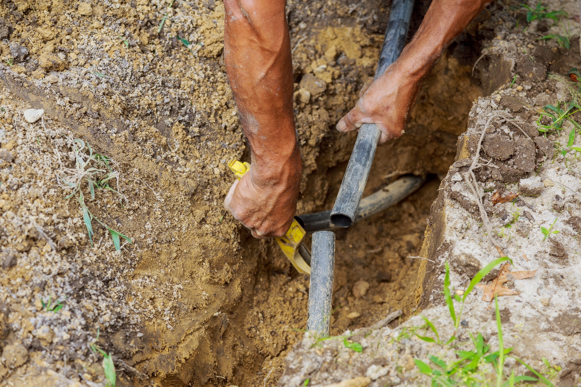 Man Working installing drop irrigation system with Pipes in Ground